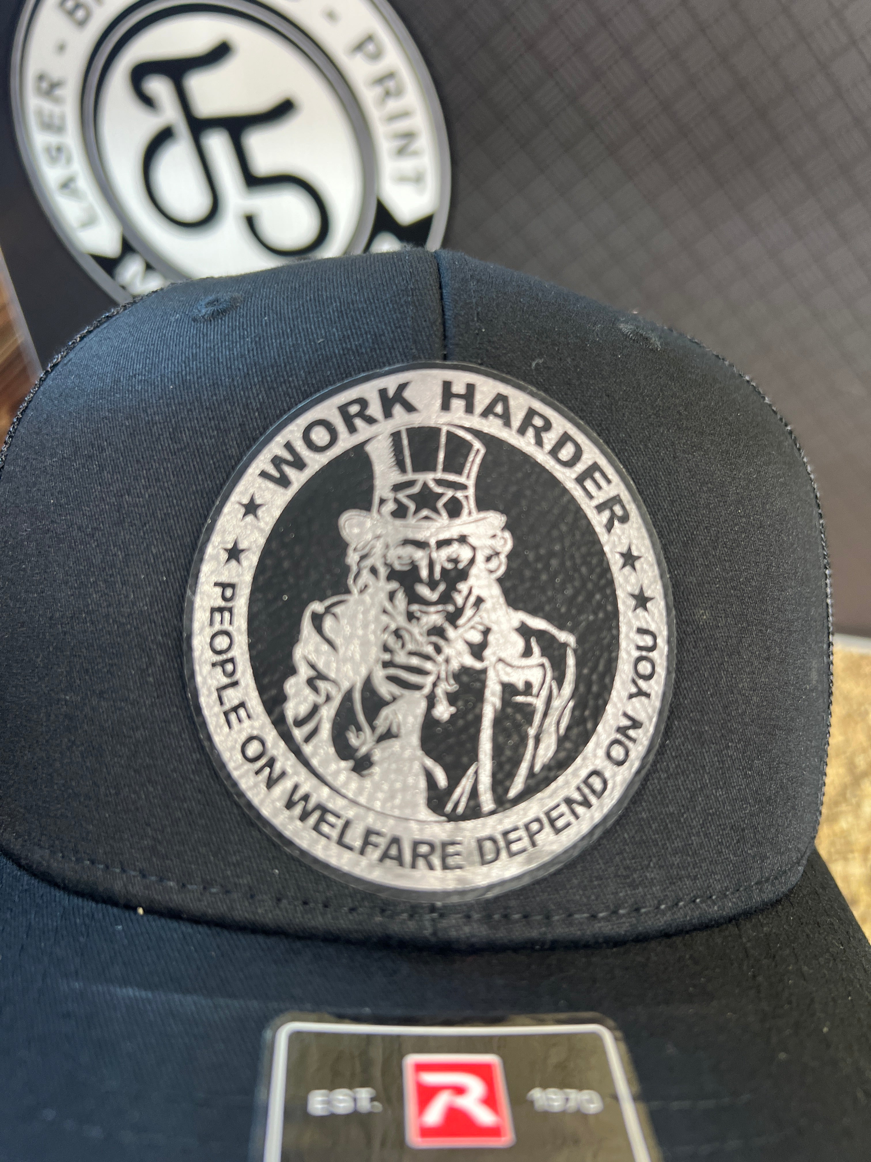 Work Harder Hat Design with a Premium Leatherette Patch on a Richardson 112 Trucker Hat for Conservative Americans.