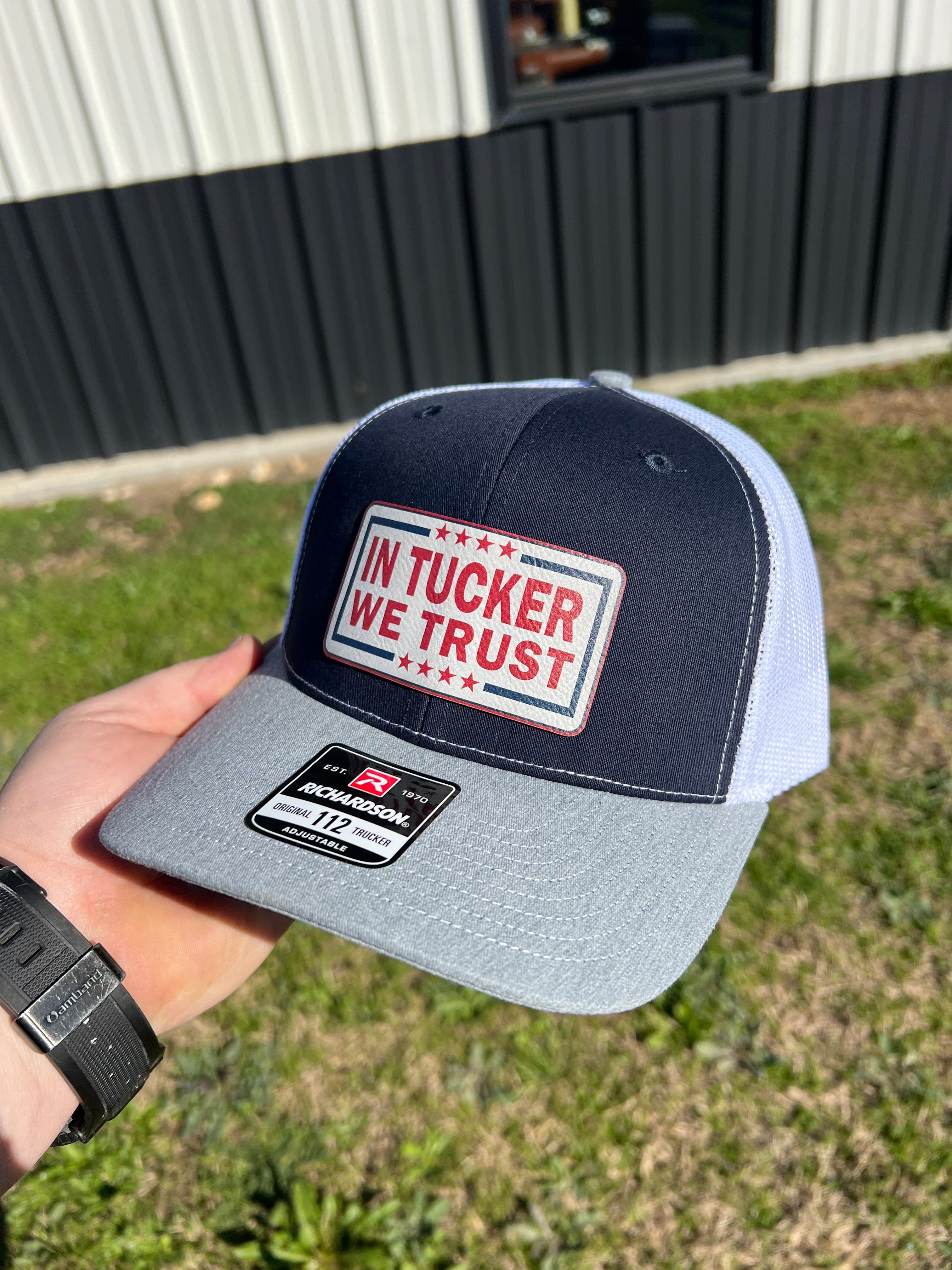 In Tucker We Trust Hat with Laser Engraved Premium Leatherette Patch on a Richardson 112 Trucker Hat.