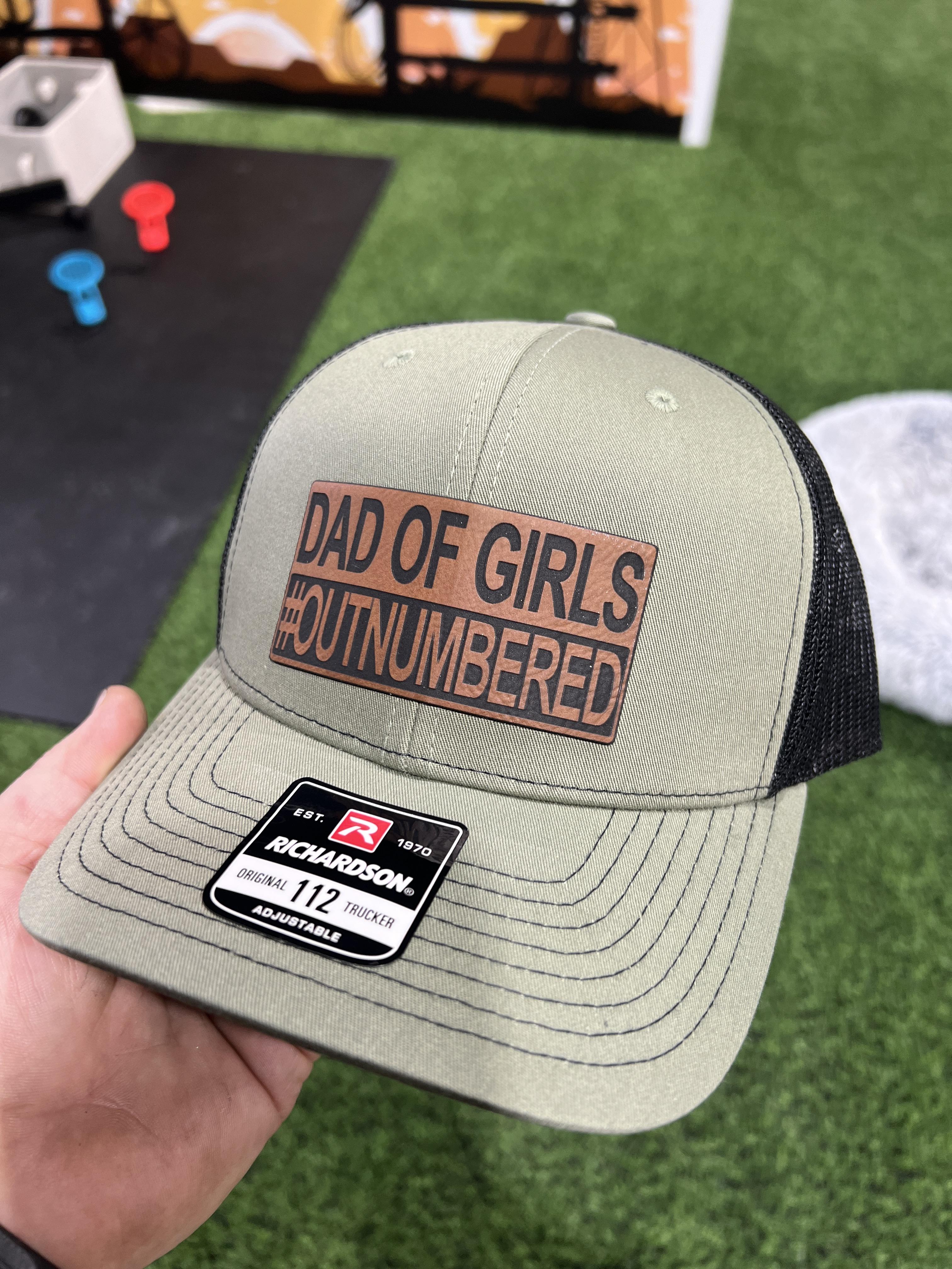 Dad of Girls OUTNUMBERED Leatherette Patch Hat is a Richardson 112 Trucker Hat with adjustable snapback.